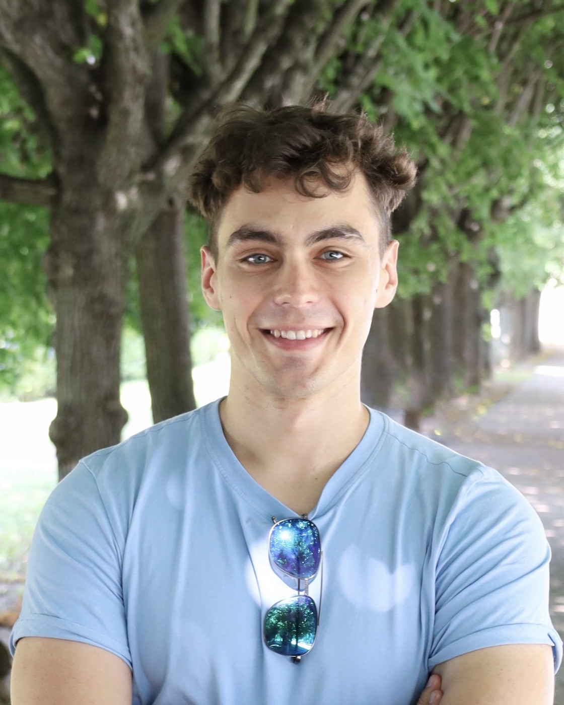 David Novák smiling in a tree alley
